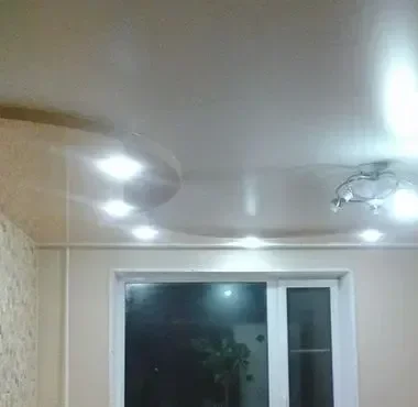 Натяжной глянцевый потолок со встроенными светильниками.